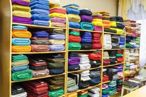 estantes con telas de diferentes colores en la tienda de textiles de élite foto