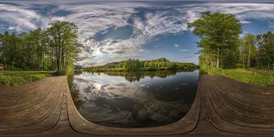 vista de ángulo de 360 grados de panorama hdri esférico completo en el muelle de madera del lago o río en la mañana o al atardecer con hermosas nubes en proyección equirectangular, contenido vr foto