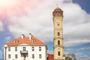 edificios históricos de la torre de vigilancia contra incendios en grodno, bielorrusia durante el día del sol con hermosas nubes foto