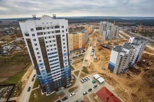 Panoramic view on construction of  new quarter Tower unfinished multi-storey high building from a bird's eye view with forest on background photo