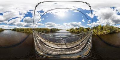 Antena completa sin fisuras esférica 360 grados de ángulo vista panorámica desde el puente de madera de suspensión peatonal sobre el río ancho en un día soleado en proyección equirectangular. skybox para contenido vr ar foto