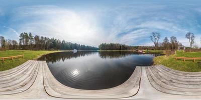 Vista panorámica completa de 360 ángulos con vapor blanco en la estación de botes en el lago en un día soleado. skybox como fondo en proyección equidistante esférica equirectangular para contenido vr ar foto