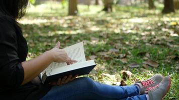 dame se détendre en lisant un livre dans un jardin verdoyant video