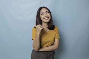 Young pretty woman smiling joyfully and looking happy, feeling carefree and positive with both thumbs up isolated by blue background photo