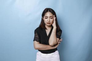 Tired sleepy woman, has a sad expression, closes her eyes, hard Monday. Isolated blue background photo