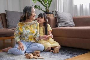 Grandmother and granddaughter play games. Blockwood Puzzle To develop skills for granddaughter and as a holiday activity photo