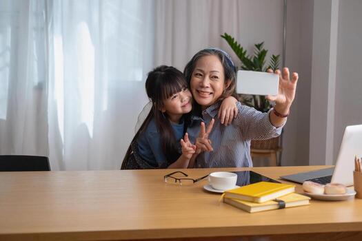 retrato de una anciana sosteniendo un teléfono celular para tomar una foto de ella y su nieta para futuras referencias.