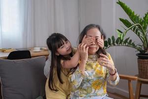 Portrait of a grandmother and granddaughter doing home activities and showing love for one another to create warmth and love within the family. photo