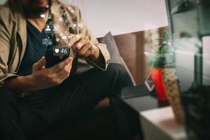 mano hipster usando un teléfono inteligente, teclado de acoplamiento de tableta digital, taza de café, negocios en línea de pagos, sentado en un sofá en la sala de estar, concepto de trabajo en casa foto