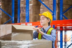 trabajadora de almacén trabajando en almacén de distribución, trabajadora de embalaje de destilería inspeccionando el producto en la caja foto