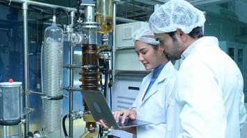 Scientists and assistants are in the machine room extracting oil and cannabis seeds. Inspecting cannabis oil extractor before starting to extract the prepared cannabis photo