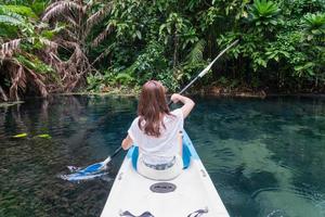 Young woman tourist paddling the kayak at klong root in Krabi, Thailand photo