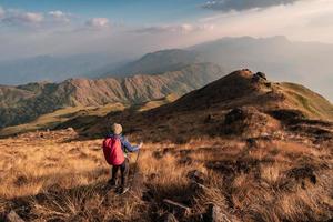 joven viajero con mochila trekking en la montaña, concepto de estilo de vida de viajes de aventura foto