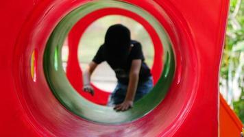 menino de 7 anos brincando no playground do túnel video