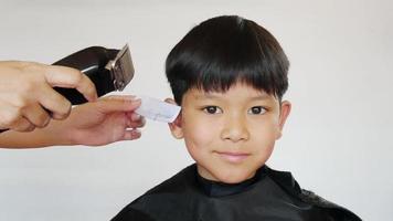 un garçon se fait couper les cheveux par un coiffeur video