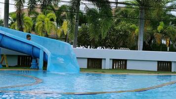 il ragazzo dei fratelli sta giocando felicemente con lo slider nella piscina d'acqua video