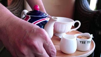 gente de negocios de café y panadería y concepto de servicio, hombre o camarero está sirviendo té caliente en una cafetería - primer plano a mano y recipiente de té caliente en una mesa video