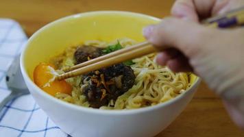 signora che mangia noodle istantanei usando il cuoco delle bacchette con uova e carne di maiale e verdure - concetto di consumo veloce di noodle video