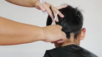 Ein Junge wird vom Friseur die Haare geschnitten video