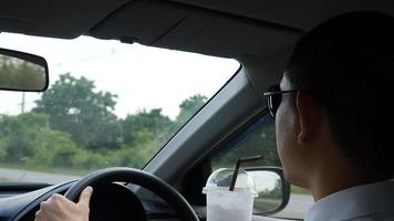 Man is dangerously drinking cup of cold coffee while driving a car video