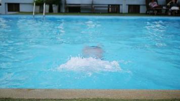 niño de quince años está nadando felizmente en la piscina de agua video