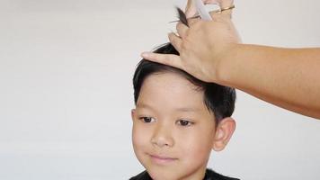 un garçon se fait couper les cheveux par un coiffeur video