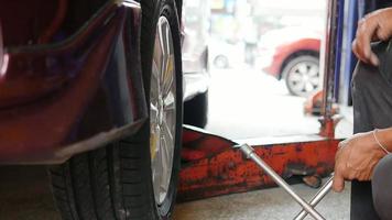 técnico que realiza el mantenimiento del sistema de neumáticos de automóviles en el garaje - concepto de mantenimiento de automóviles video