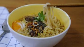 signora che mangia noodle istantanei usando il cuoco delle bacchette con uova e carne di maiale e verdure - concetto di consumo veloce di noodle video