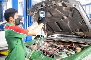 revisión del aire acondicionado del automóvil técnico de servicio detección de fugas agregue una máquina refrigerante y un medidor para medir el aire de refrigeración en el automóvil foto