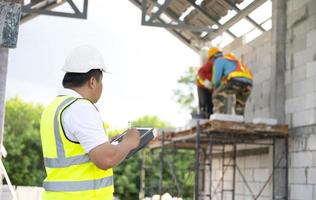 Engineers and architects supervise the construction of houses on residential construction sites. photo