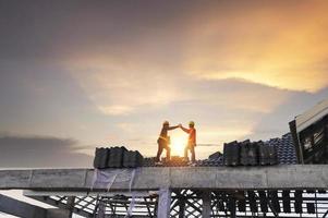 A team of construction workers in work clothes installed new roofing equipment. roofing tools, electric drill, and use it on new wood roofs with metal sheets. photo