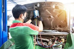 revisión del aire acondicionado del automóvil técnico de servicio detección de fugas agregue una máquina refrigerante y un medidor para medir el aire de refrigeración en el automóvil foto