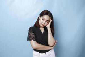 Tired sleepy woman, has a sad expression, closes her eyes, hard Monday. Isolated blue background photo