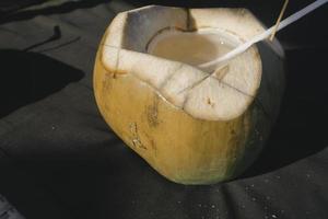 imagen de jugo de coco fresco en una playa tropical foto