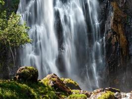 el agua que cae en una cascada crea una nube de polvo de agua. foto