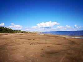 Large sandy beach on the shore of the sea or lake photo