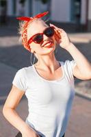 Portrait of a stylish young hipster girl with sunglasses in the city. photo