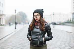 Portrait of a beautiful girl in glasses on a background of street photo