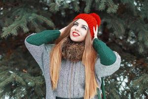 Young beautiful girl with red lips and a knitted hat walks in the park. Good time holidays photo