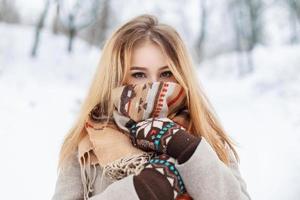 Portrait of a beautiful girl in a scarf and gloves in winter park. Vintage collection. Keep warm photo