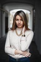 hermosa joven con una cadena de oro y un reloj retro posando en la calle foto