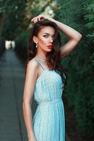 Fashion portrait of a beautiful girl in a turquoise dress with red lips. photo