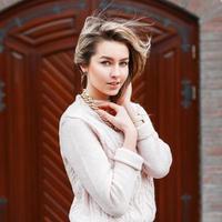 Young beautiful girl in a sweater on the background of the door. photo
