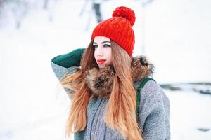Beautiful girl in a knitted fashionable clothes in winter day on the background of a snowy field photo