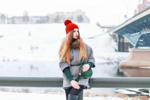 linda jovencita en el frío clima invernal cerca del río foto