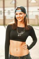 Hip-hop dancer girl in stylish black clothes and cap in the sunlight. photo
