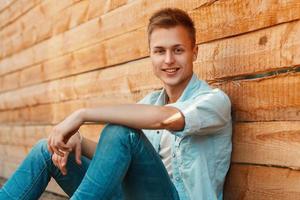 Young boy near a wooden wall. photo