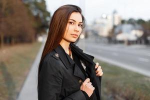 Portrait of a young fashionable girl in a black cloak photo