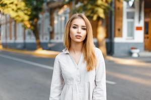 hermosa mujer elegante con ropa elegante posando en un día soleado foto