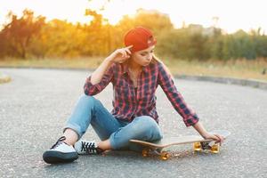 Woman with skateboard at sunset. photo